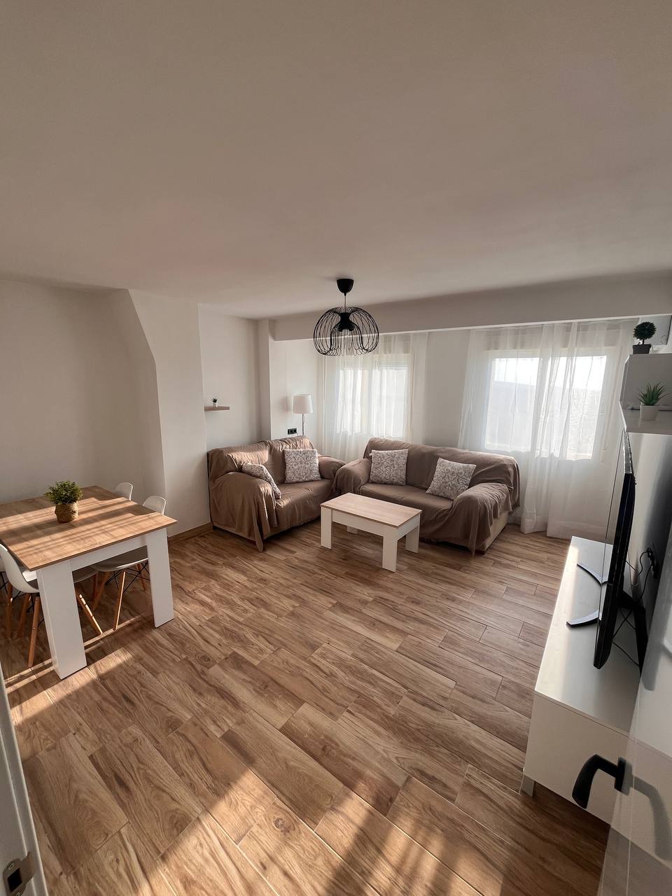 Salón con sofás, mesa de comedor y televisión